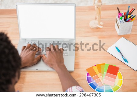 Young businessman types on the laptop in the office