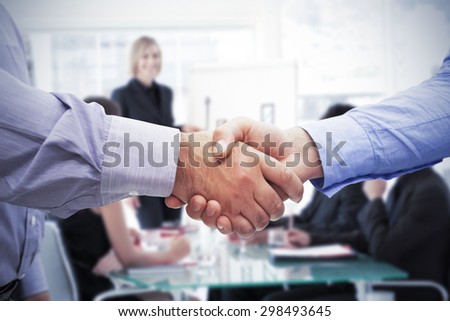 Men shaking hands against businesswoman reporting to sales in a seminar