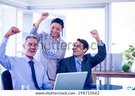 Happy business people cheering together in office