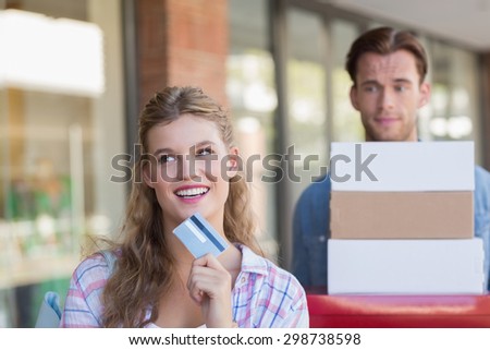 A happy couple showing their new credit card at the mall