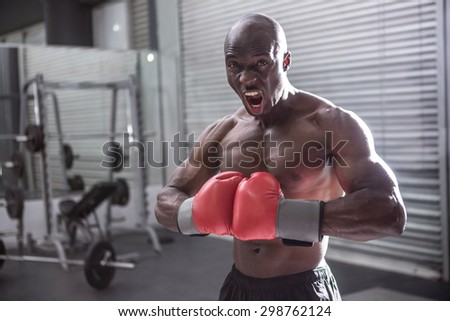 Young Bodybuilder posing in front of the camera in the gym