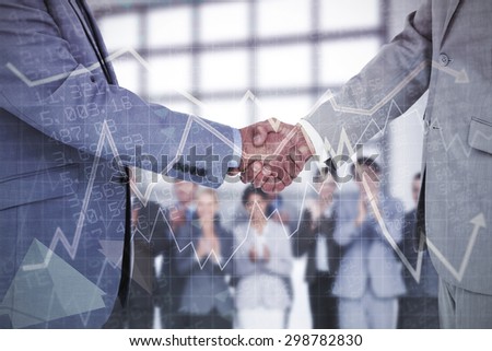 Side view of shaking hands against stocks and shares