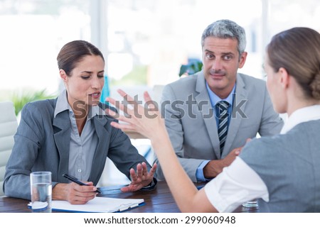 Business people interviewing young businesswoman in office