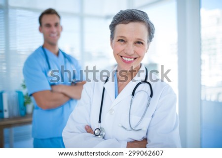 Portrait of two smiling colleagues doctors with arms crossed