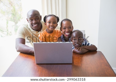 Happy smiling family using laptop at home
