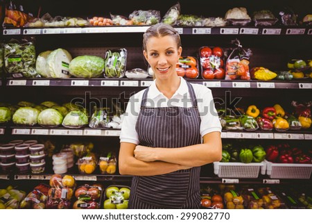 Happy pretty blonde looking at camera with arms crossed in supermarket
