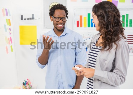 Young smiling creative business people at the office looking and talking to each other