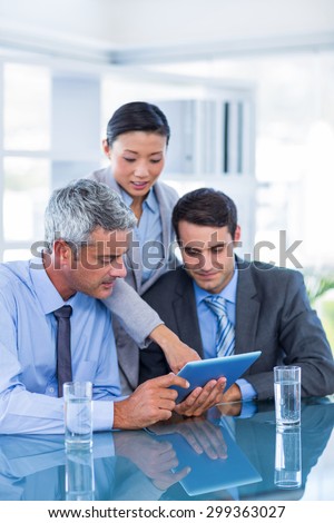 Business people looking at tablet computer in office
