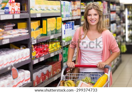 Portrait of a pretty smiling blonde woman buying products in supermarket