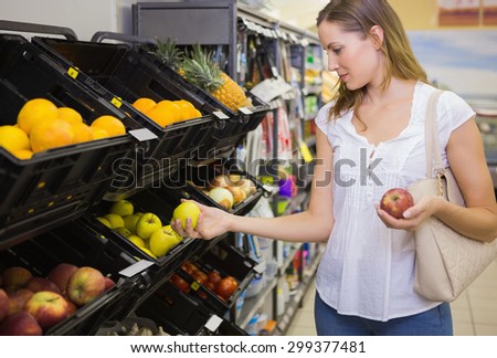Smiling pretty blonde woman buying products at supermarket