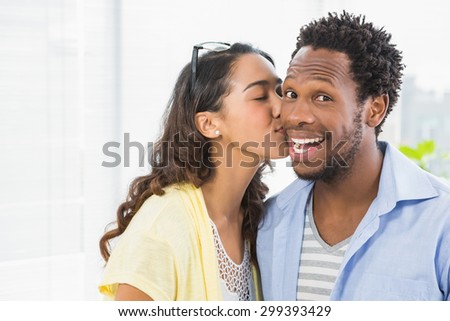 Portrait of a woman kissing her colleague in the office