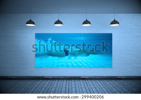 Fit swimmer training on his own against grey room