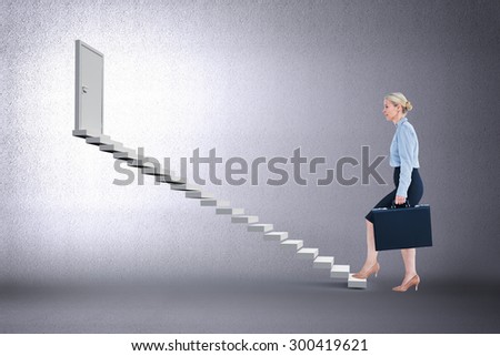 Businesswoman climbing with briefcase against grey room