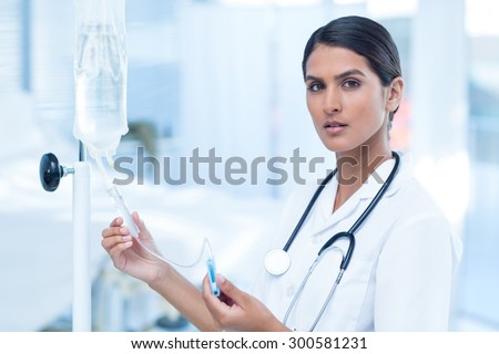 Nurse connecting an intravenous drip in hospital room