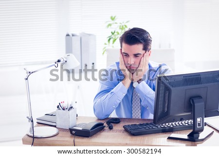 Sad businessman sitting at his desk in the office