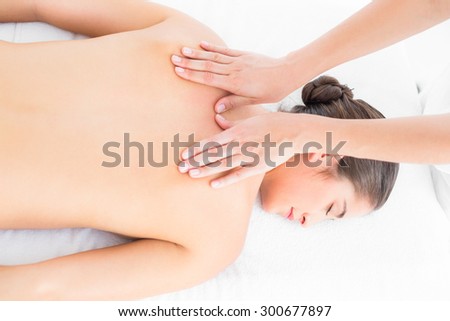 Pretty brunette enjoying a back massage at the health spa