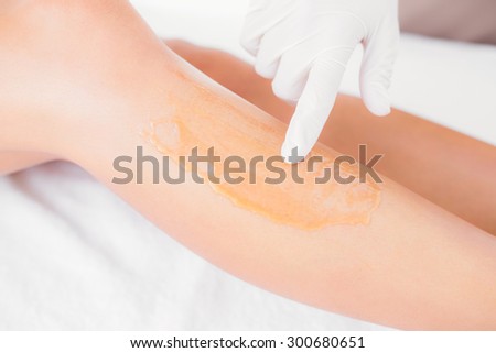 Close up side view of female leg with hot wax at spa center