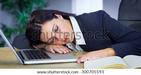 Businesswoman taking a nap on her desk in her office