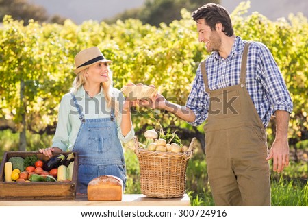 Happy farmer couple handing eggs at the local market