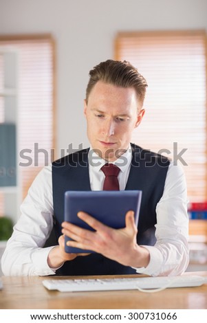 Focused businessman using his tablet pc in his office