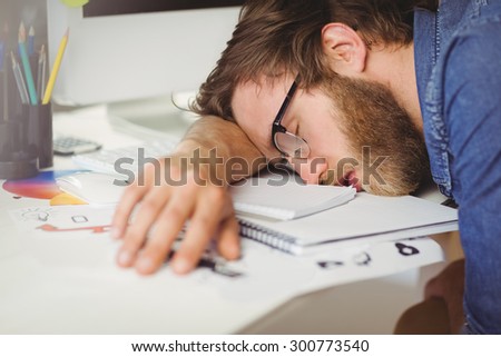 Hipster businessman sleeping at his desk in his office