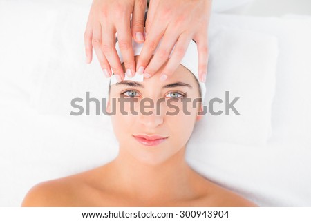 Close up of a hand waxing beautiful womans eyebrow