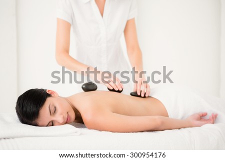 Pretty woman receiving a hot stone massage at the health spa