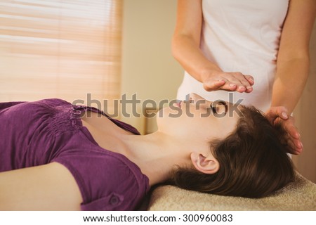 Young woman having a reiki treatment in therapy room