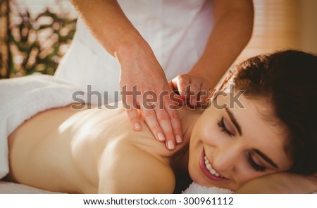 Young woman getting shoulder massage in therapy room