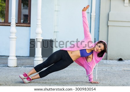 Athletic woman exercising side plank in the city