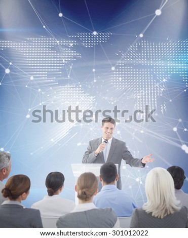 Businessman doing speech during meeting against glowing world map on black background