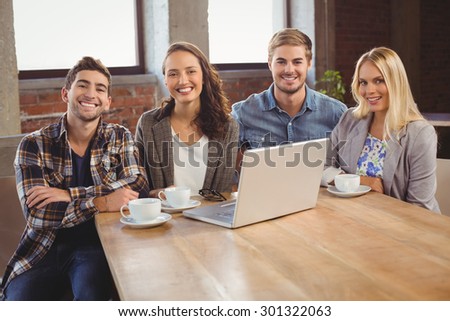 Portrait of smiling friends having coffee together at coffee shop
