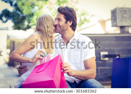 Woman kissing her smiling boyfriend after receiving a gift at shopping mall