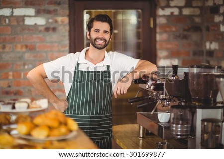 Portrait of a barista leaning on the coffee machine at the coffee shop