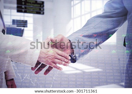 Close up of business people shaking their hands against stocks and shares
