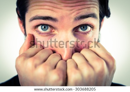 Scared hipster with hands to face on vignette background