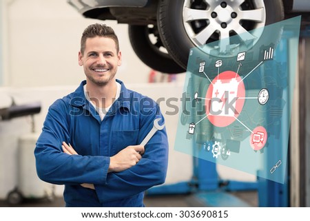 Engineering interface against mechanic smiling at the camera holding tool