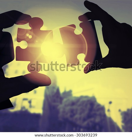 Mid section of a businessman in suit with hands out against jigsaw