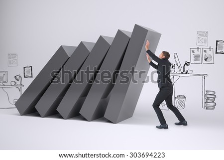 Businessman with his hands up against falling blocks