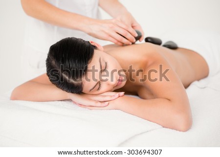 Pretty woman receiving a hot stone massage at the health spa
