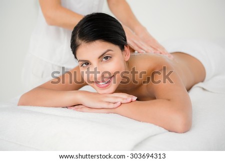 Portrait of smiling woman receiving a salt scrub massage at the health spa