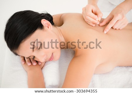 Pretty woman in an acupuncture therapy at the health spa