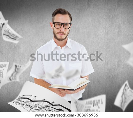 Geeky young man reading from black book against white and grey background