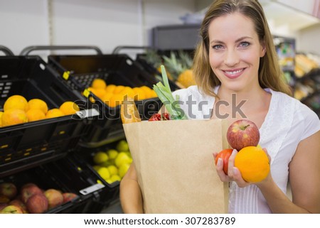 a pretty blonde with a grocery bag in the supermarket