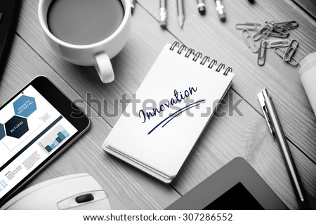 The word innovation and business interface against notepad on desk
