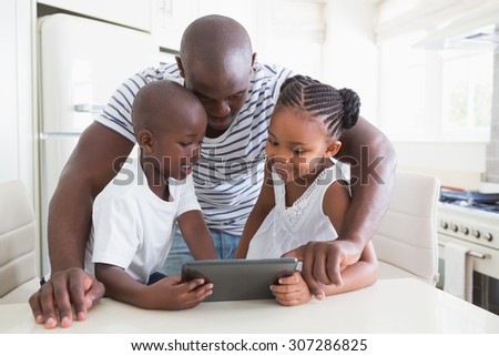Happy familyon table with digital tablet in the kitchen