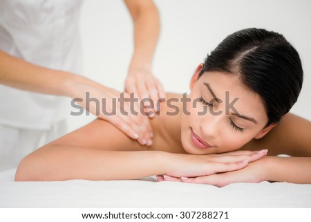 Pretty brunette enjoying a massage at the health spa