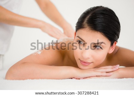 Woman enjoying a salt scrub massage at the health spa