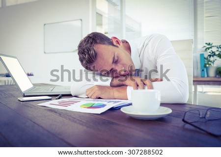 Exhausted businessman sleeping on the desk in the office