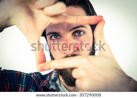 Handsome hipster framing with hands on vignette background